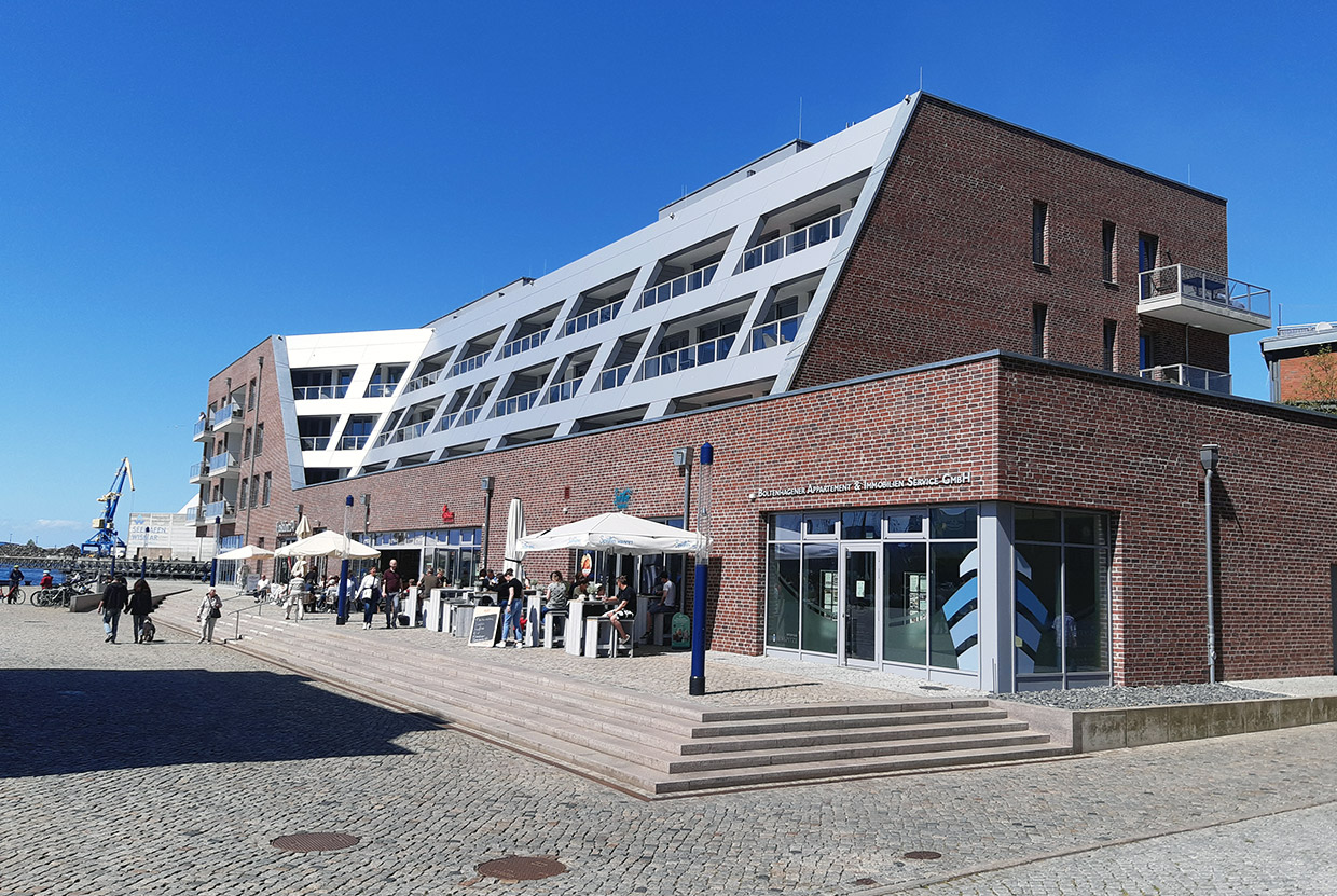 Die Fassade übernimmt die traditionellen Materialien der Nachbargebäude am Alten Hafen . Neubau Wohn- und Geschäftshaus Hafenspitze, Wismar